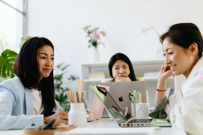 a group of women sitting around a table with laptops, by Jang Seung-eop, trending on pexels, avatar image, background image, ethnicity : japanese, three women