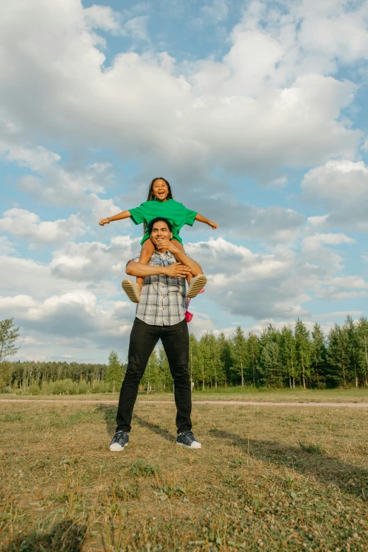 a man holding a little girl on his shoulders, by Jaakko Mattila, pexels contest winner, symbolism, in a open green field, square, macho pose, northern finland