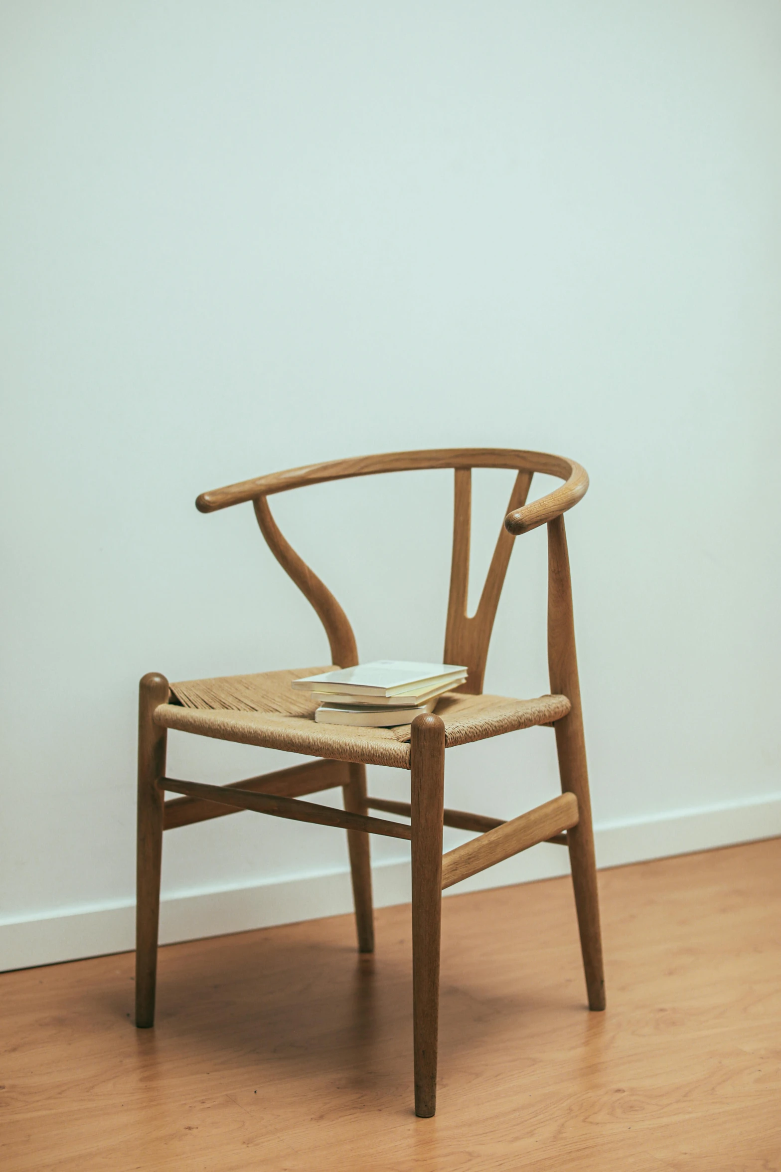 a wooden chair sitting on top of a hard wood floor, inspired by Constantin Hansen, pexels contest winner, thin antlers, reading, são paulo, plain background