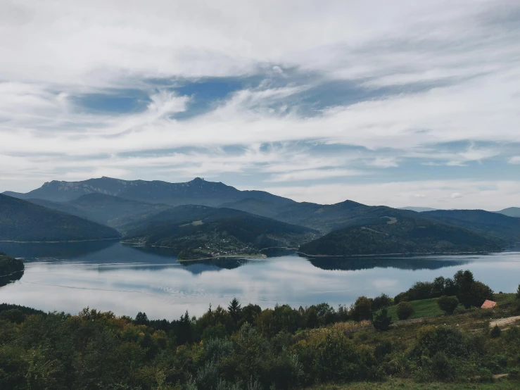 a large body of water surrounded by mountains, by Emma Andijewska, pexels contest winner, hurufiyya, carpathian mountains, panorama distant view, thumbnail, multiple stories