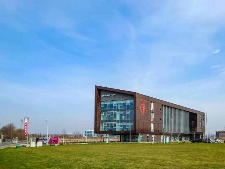 a large building sitting on top of a lush green field, academic art, coper cladding, paisley, at netflix, panoramic shot