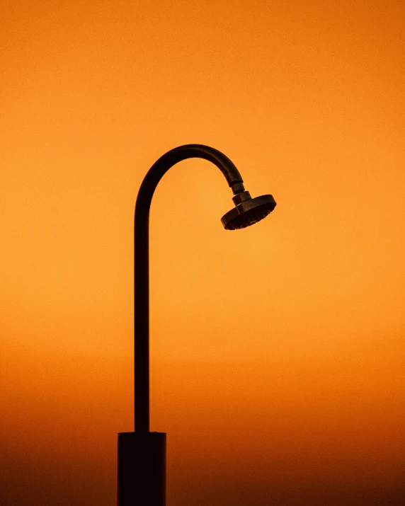 a street light with the sun setting in the background, an album cover, unsplash, conceptual art, showers, orange color, water pipe, minimalist photo