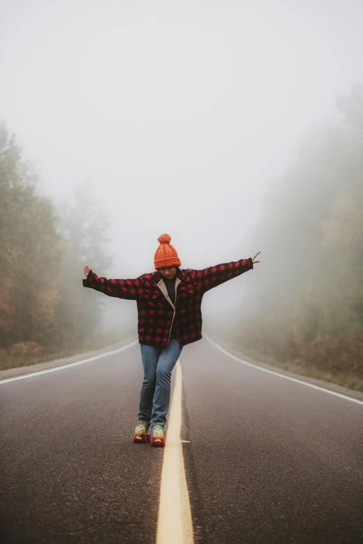 a person riding a skateboard on a foggy road, by Jessie Algie, pexels contest winner, pose(arms up + happy), lumberjack flannel, vacation photo, college