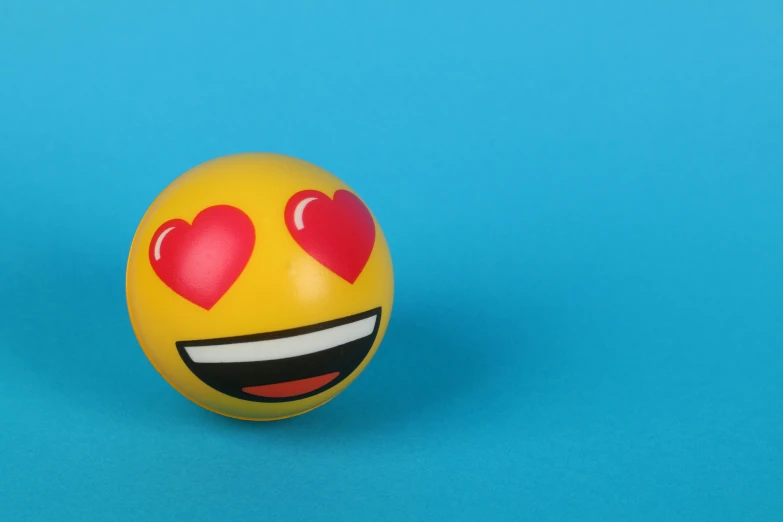 a smiley face ball with hearts on it, by Gavin Hamilton, trending on pexels, 3 d print, emoticon, with a blue background, from the distance