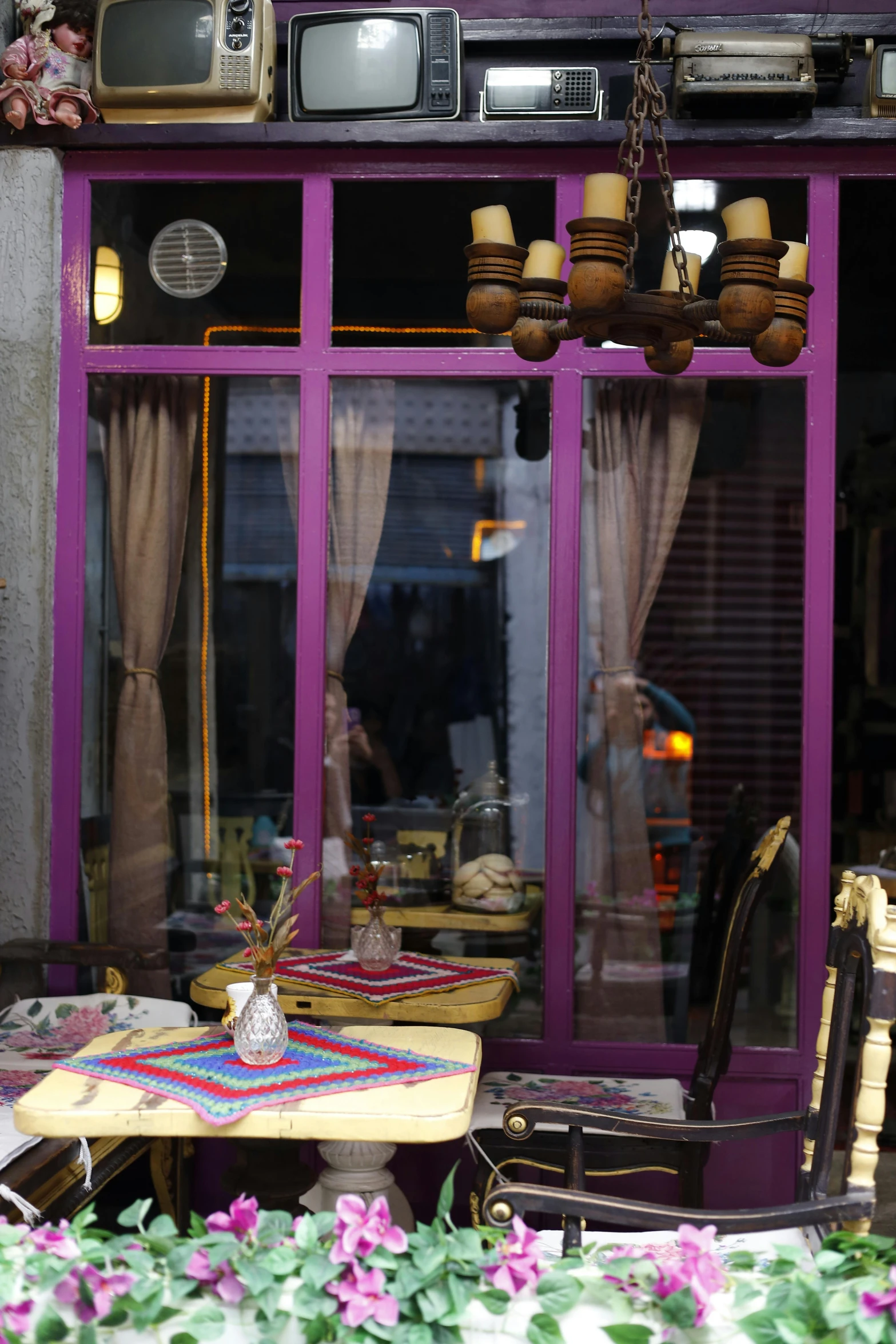 a television sitting on top of a table in front of a window, inspired by Osman Hamdi Bey, art nouveau, cafe, pink door, purple accents, medium close shot