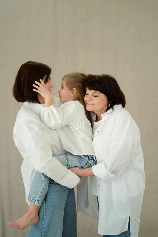 a woman holding a little girl in her arms, an album cover, by Attila Meszlenyi, pexels contest winner, incoherents, white shirts, three women, studio photo, 15081959 21121991 01012000 4k