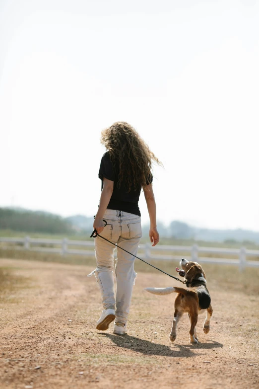 a woman walking a dog down a dirt road, profile image, denim, lunging at camera :4, pets