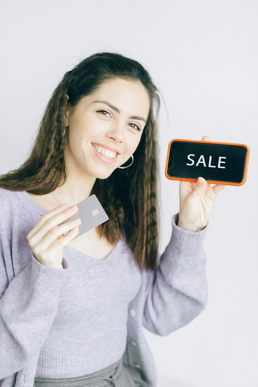 a woman holding a credit card and a sale sign, pexels contest winner, square face, grey, crypto, small