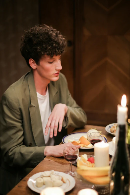 a man sitting at a table with a plate of food, trending on unsplash, renaissance, beautiful androgynous prince, candle lighting, non binary model, wearing jacket