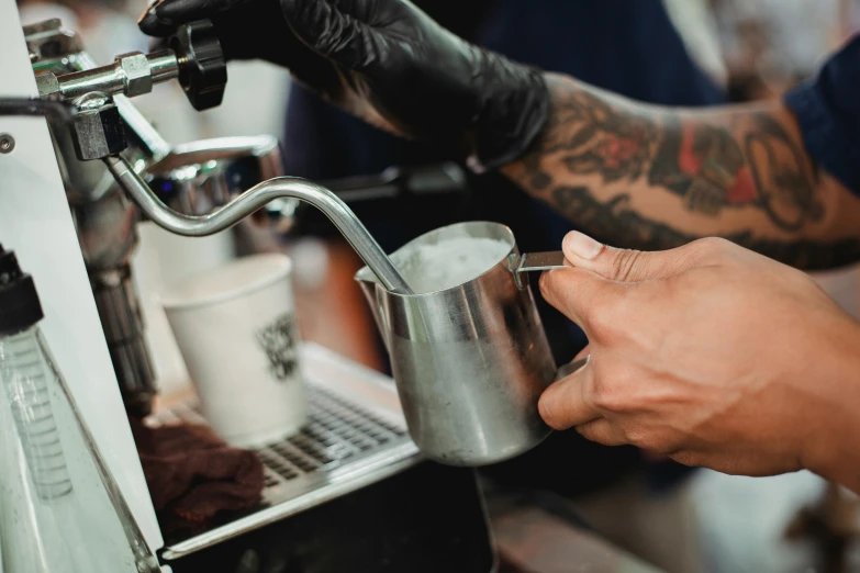 a close up of a person pouring something into a cup, by Niko Henrichon, pexels contest winner, aussie baristas, tattooed, shiny silver, thumbnail