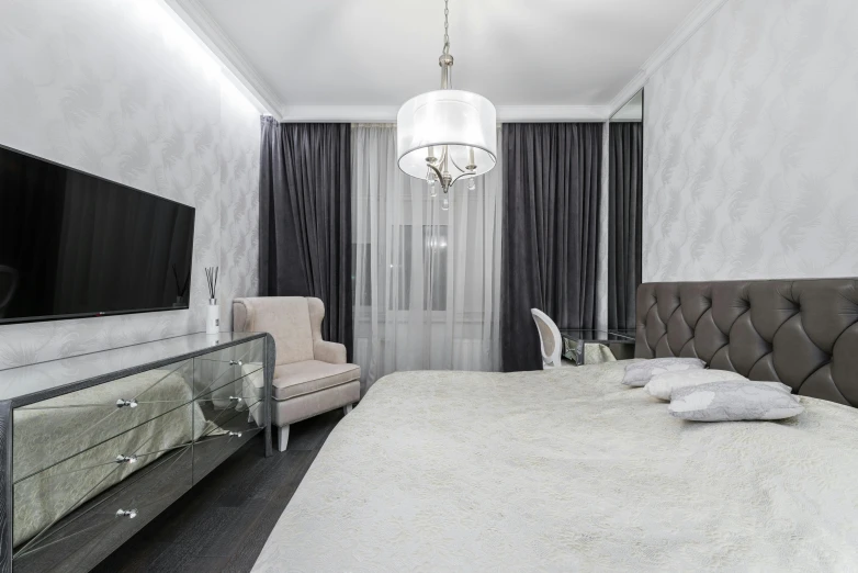 a bed room with a neatly made bed and a flat screen tv, by Adam Marczyński, pexels contest winner, neoclassicism, white and silver, beaded curtains, high gloss