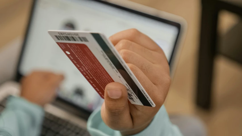 a person holding a credit card in front of a laptop, by Carey Morris, pexels contest winner, faked service ticket, avatar image, loosely cropped, ad image