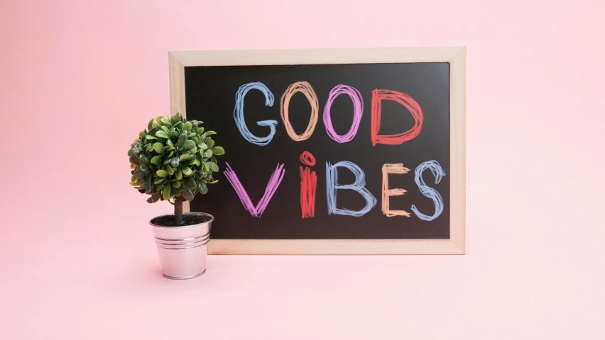 a sign that says good vibes next to a potted plant, pexels contest winner, blackboard, pink hue, 1 6 x 1 6, happy colours