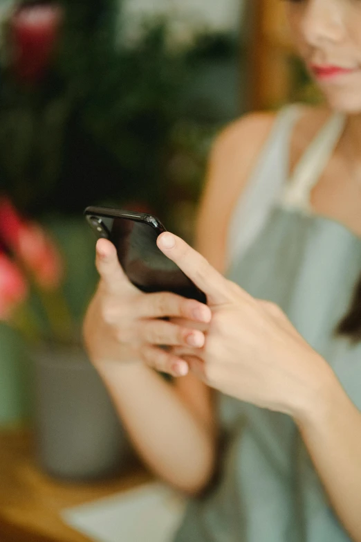 a woman is looking at her cell phone, pexels, square, at checkout, 1 4 5 0, hazy