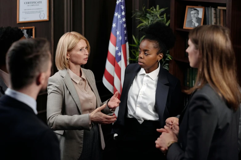 a group of people standing around each other, female lawyer, television still, profile image