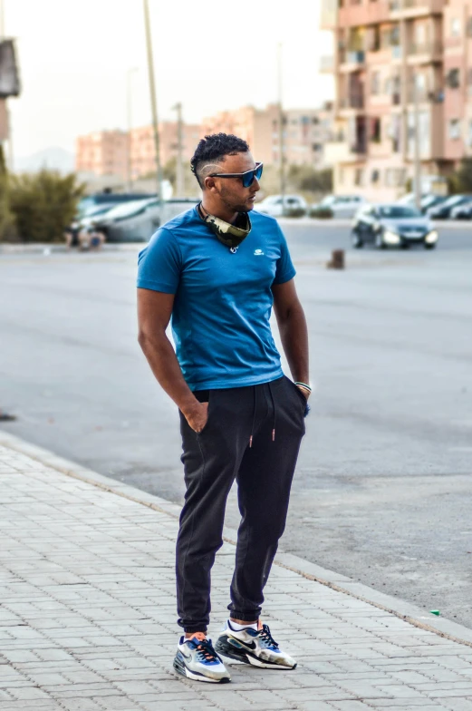 a man standing on a sidewalk with a skateboard, pexels contest winner, renaissance, wearing a dark blue polo shirt, brown skin man egyptian prince, wearing blue sunglasses, profile image