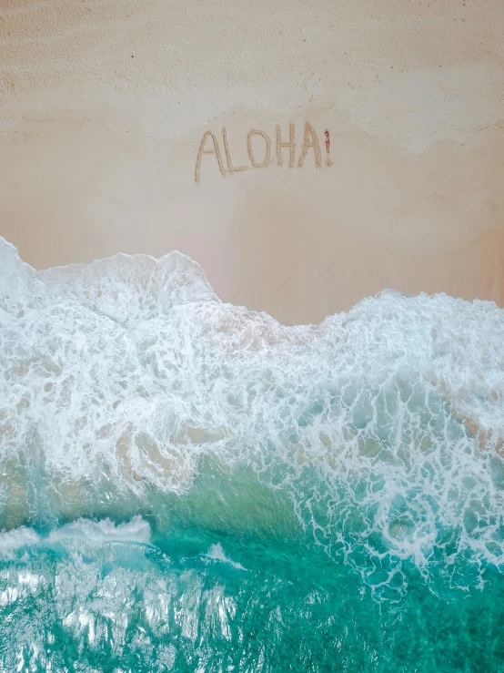 an aerial view of a beach with the word aloh written in the sand, an album cover, unsplash contest winner, hawaii, profile image, 🐿🍸🍋, ocean spray