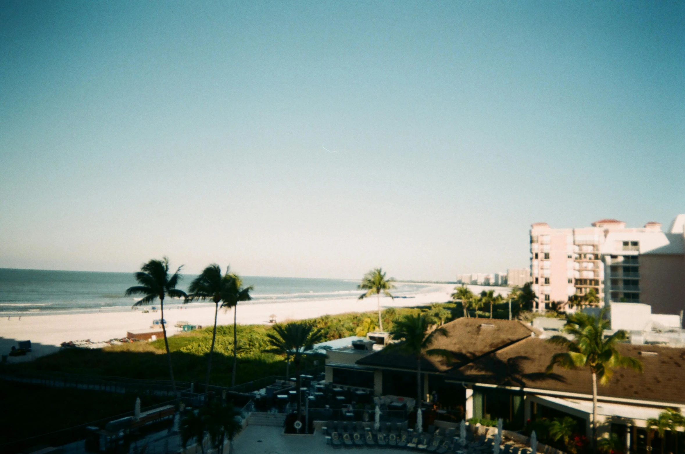 a view of the beach from the balcony of a hotel, a polaroid photo, pexels contest winner, happening, florida, shot on hasselblad, clear skies in the distance, bald head