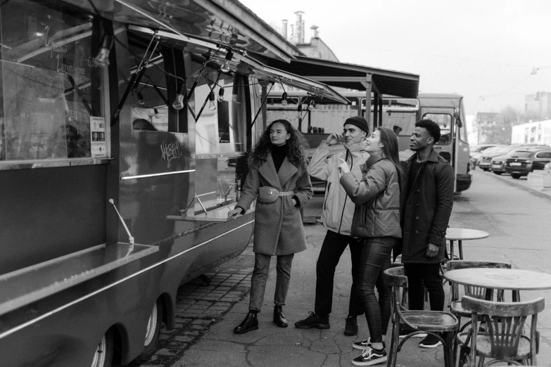 a group of people standing next to a food truck, a black and white photo, by Kristian Zahrtmann, pexels, arbeitsrat für kunst, model pose, bts, eating, f 4