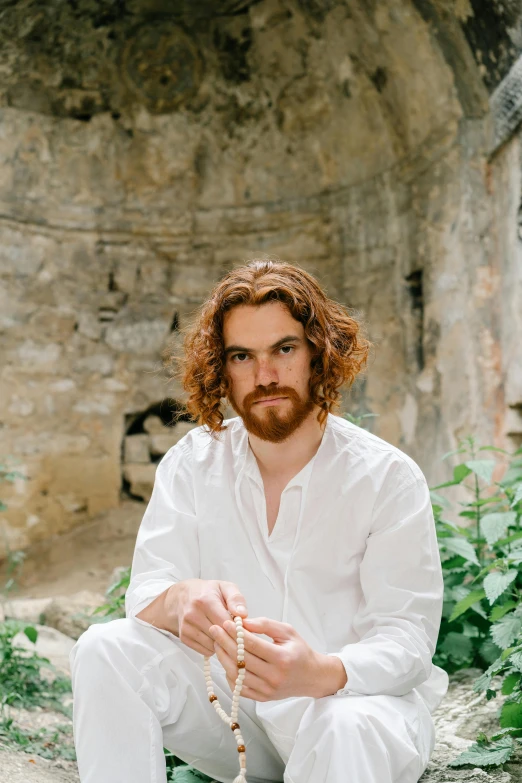 a man in a white shirt sitting on the ground, an album cover, inspired by Konstantin Vasilyev, pexels contest winner, renaissance, ginger wavy hair, sitting in a castle, headshot profile picture, orthodox