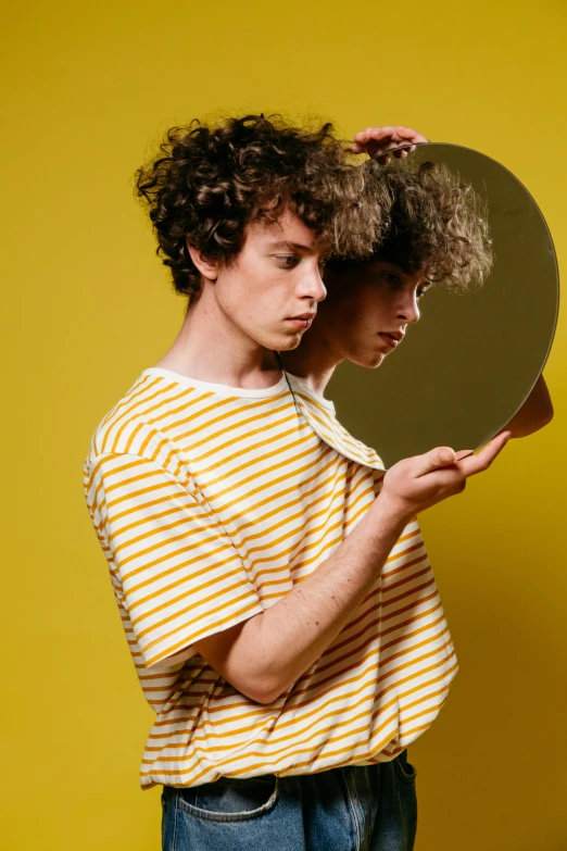 a man holding a mirror in front of his face, an album cover, trending on pexels, magic realism, wavy hair yellow theme, sophia lillis, stripes, male teenager