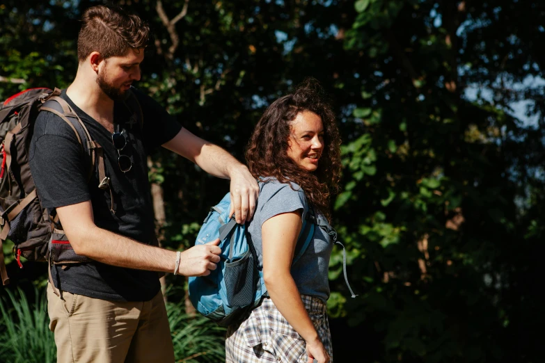 a man standing next to a woman with a backpack, happening, charli bowater and artgeem, supportive, thumbnail, explorer