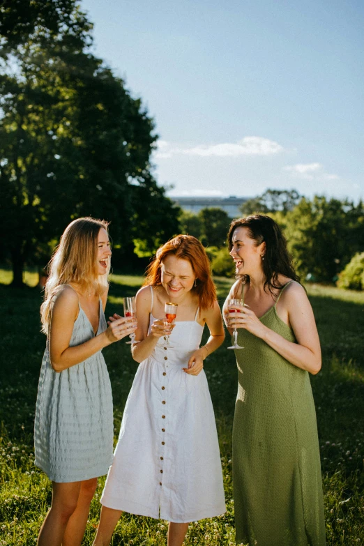 a group of women standing on top of a lush green field, enjoying a glass of wine, redhead, not cropped, lookbook