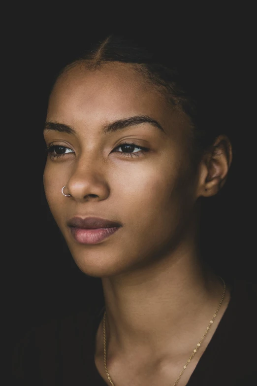 a woman standing in front of a black background, a character portrait, trending on unsplash, detailed flawless face, black young woman, good definition of cheekbones, high angle closeup portrait