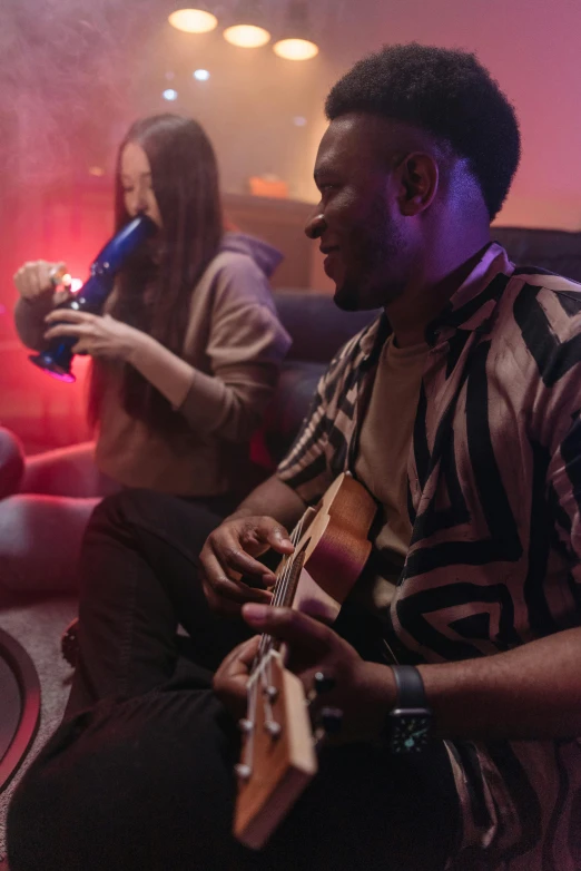 a group of people sitting on top of a couch, playing a guitar, with red haze, playing games, ukulele