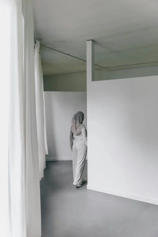 a woman in a white dress standing in a room, hijab, grey cloth, white-space-surrounding, ignant