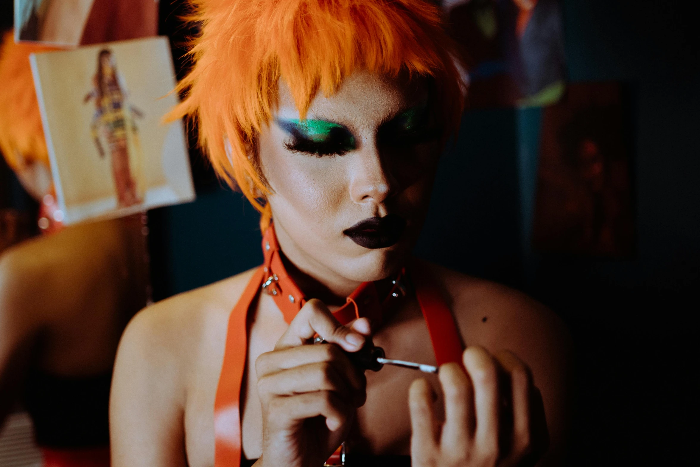 a woman with orange hair is putting on makeup, an album cover, trending on pexels, transgressive art, androgynous male, bold rave outfit, 35mm photo, nightlife