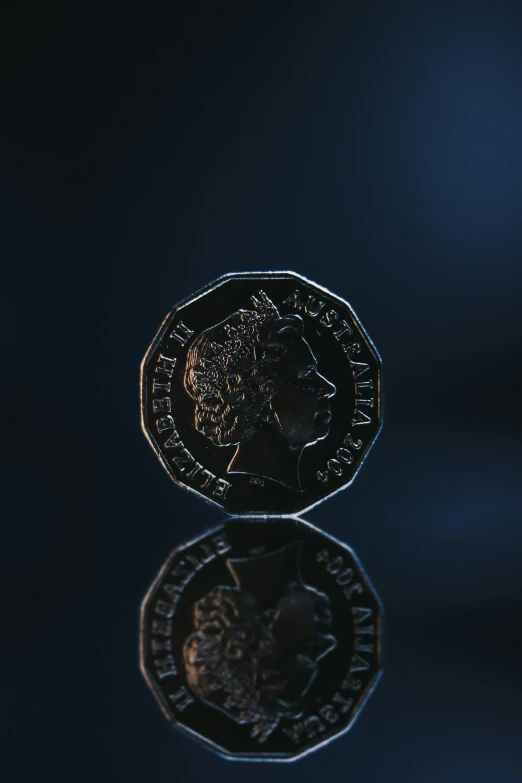 a coin sitting on top of a reflective surface, with dramatic lighting, hexagonal shaped, shot on sony a 7, shilling