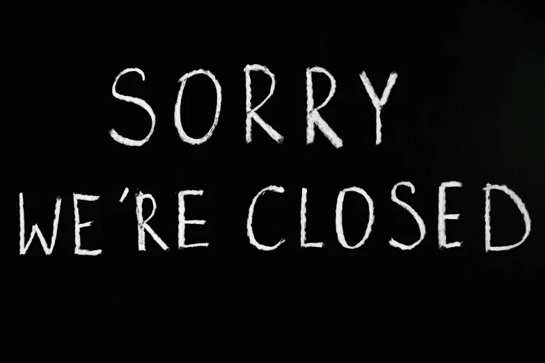 a hand writing sorry we're closed on a blackboard, by Andries Stock, pixabay, in the style of john baldessari, donnie darko, heartbroken, 3 5 mm close up