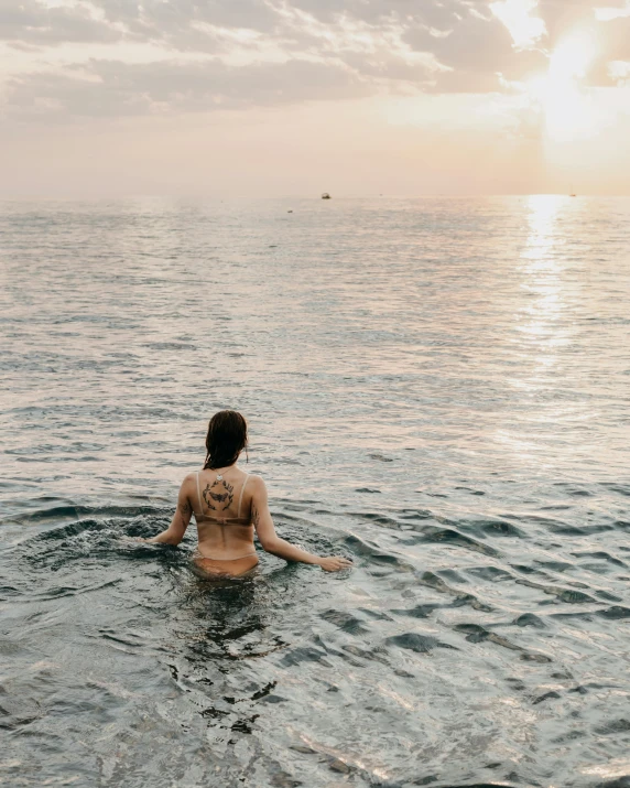 a woman sitting in the middle of a body of water, wearing nothing, instagram post, lgbtq, unsplash transparent