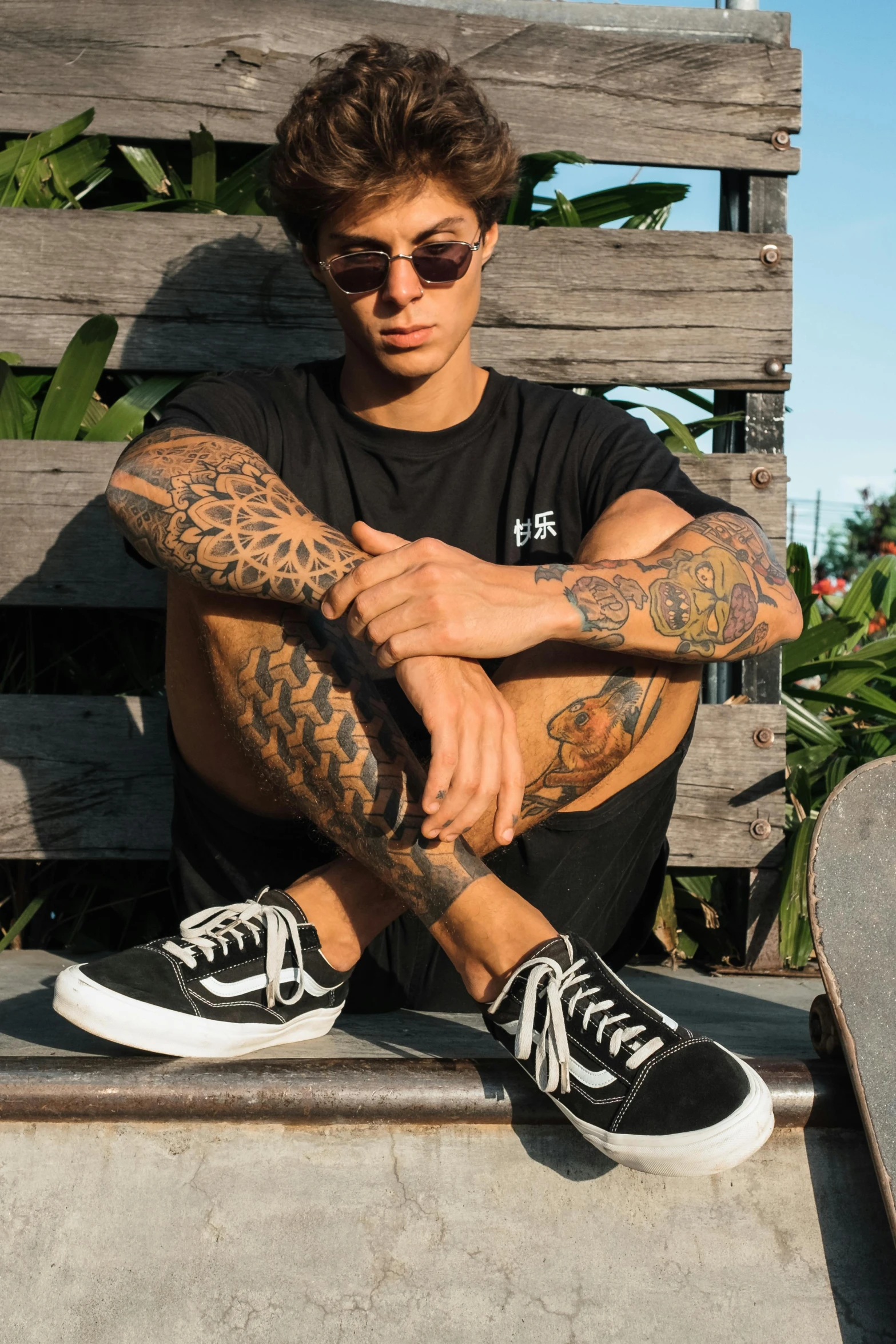 a young man sitting on top of a skateboard ramp, a tattoo, inspired by Seb McKinnon, pexels contest winner, wearing black shorts, detailed veins, handsome chad chin, shades