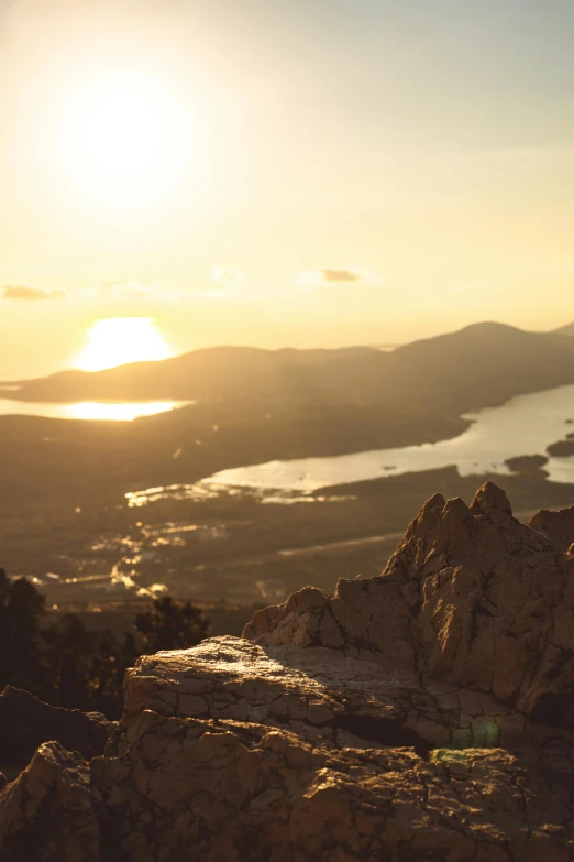 a man standing on top of a mountain next to a lake, inspired by Michael Komarck, unsplash, happening, dappled golden sunset, high view, australia, golden hour 8k