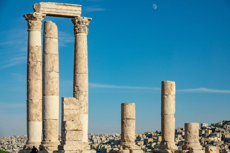 a group of columns sitting on top of a grass covered field, a marble sculpture, pexels contest winner, neoclassicism, jerusalem, ancient silver tower of the moon, square, skyline showing