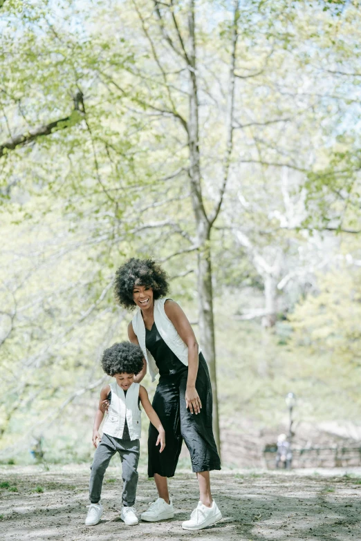 a woman and a child playing frisbee in a park, an album cover, by Lily Delissa Joseph, unsplash, visual art, willow smith young, walking through a lush forest, white and black clothing, dwell