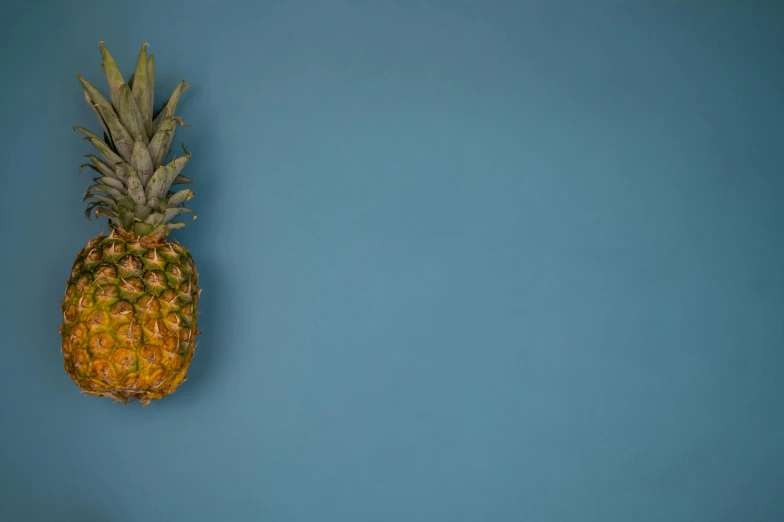 a pineapple sitting on top of a blue surface