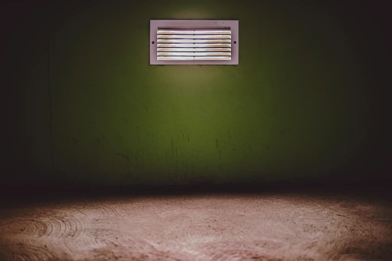 a dark room with a green wall and a small window, an album cover, pexels contest winner, floodlight, dusty floor, #green, vents