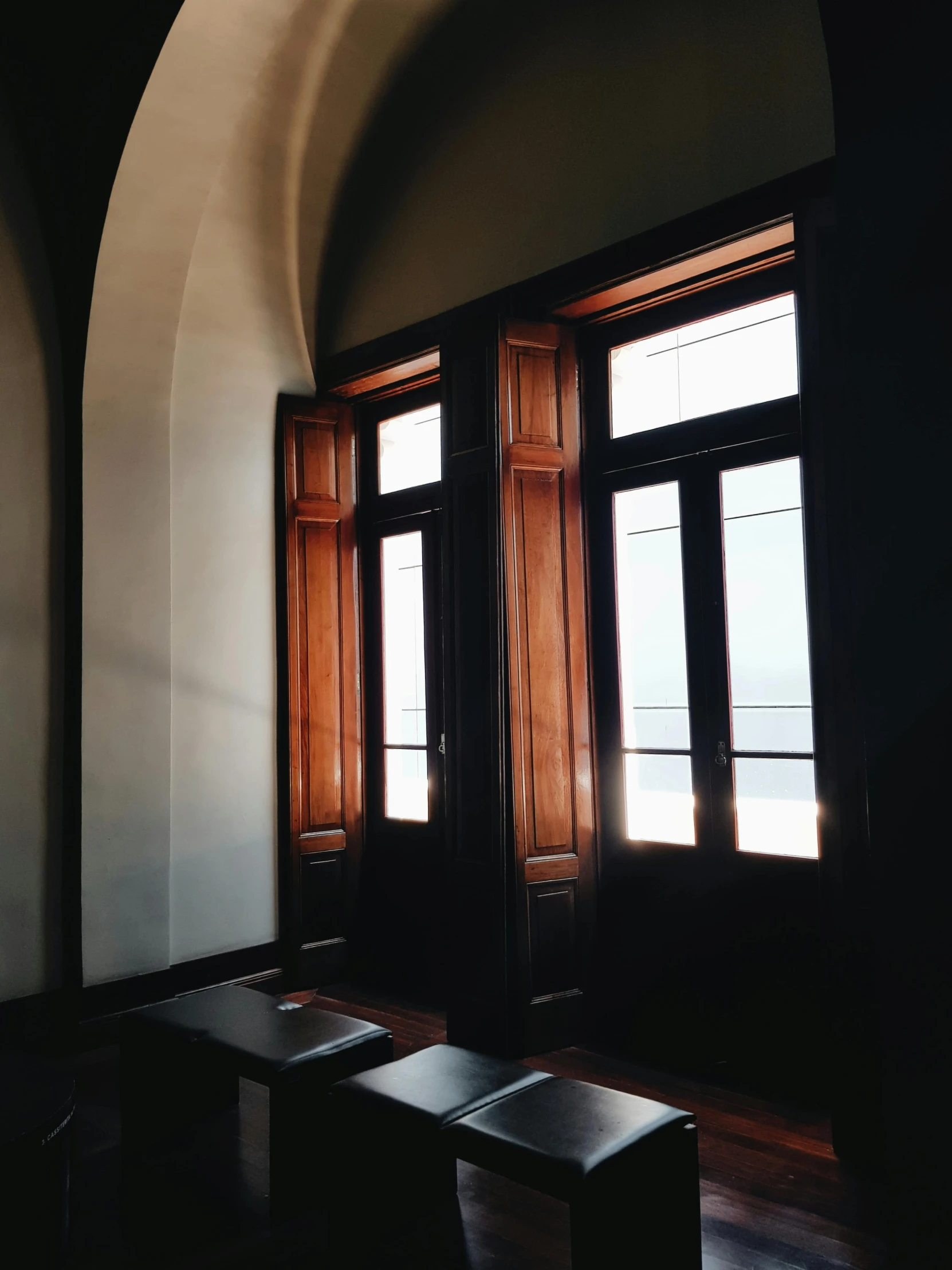 a room with a lot of windows and a bench, inspired by Bernardo Daddi, unsplash, doorway, backlighted, wooden trim, museum photo