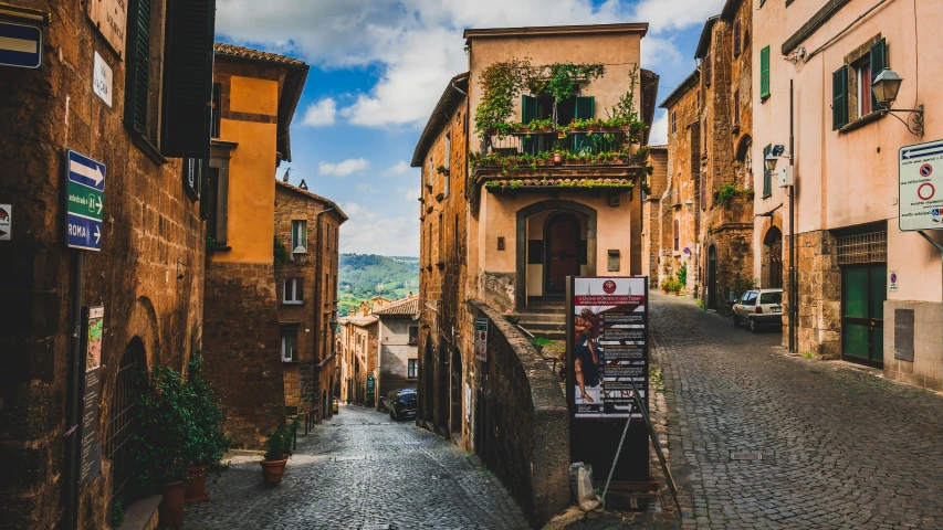 a narrow cobblestone street lined with old buildings, pexels contest winner, renaissance, countryside city scene, square, sienna, hilly road