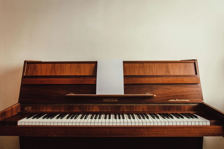 a piano sitting in the corner of a room, an album cover, unsplash, hyperrealism, ignant, 1 9 7 0 s photo, front facing, brown