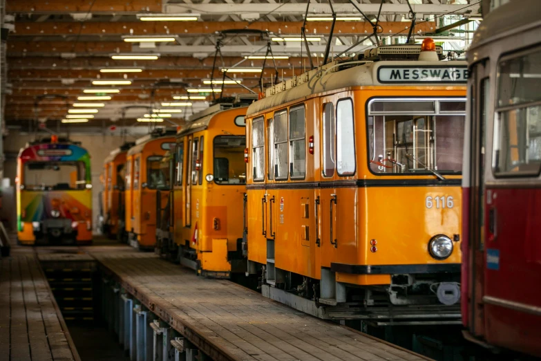 a couple of trains parked next to each other, a colorized photo, by Tobias Stimmer, pexels contest winner, hansa yellow, trams, a wooden, 🚿🗝📝