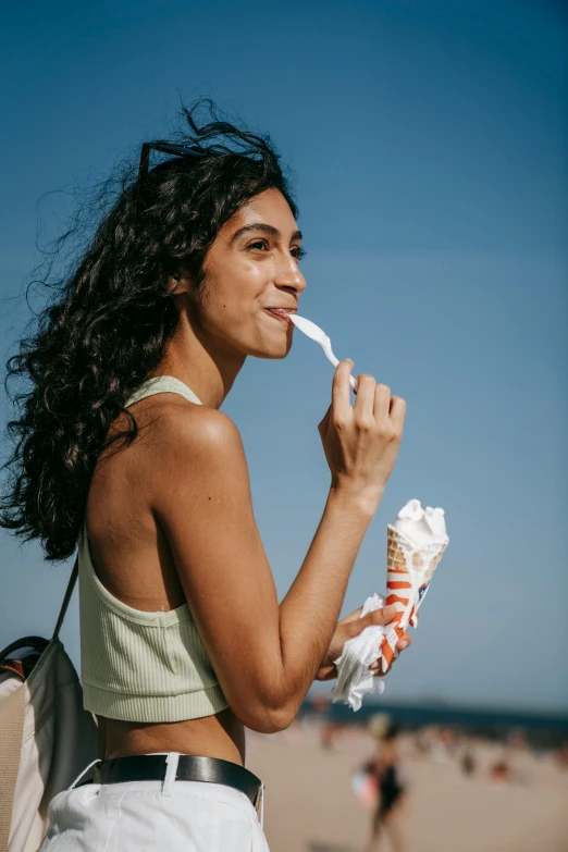 a woman brushing her teeth on the beach, trending on pexels, plasticien, ice cream cone, with long curly, candid portrait photo, sunny sky