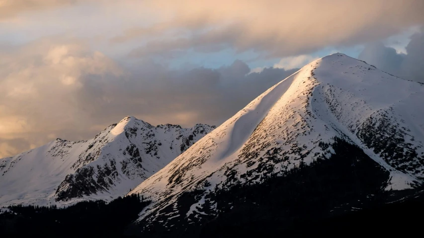 a group of snow covered mountains under a cloudy sky, by Peter Churcher, unsplash contest winner, hurufiyya, dappled in evening light, 2000s photo, at sunrise in springtime, portrait photo