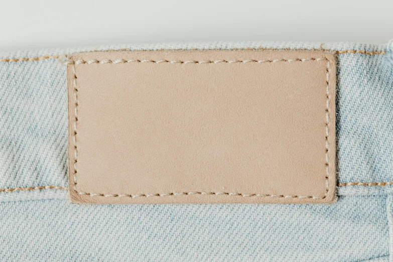 a leather label on the back of a pair of jeans, trending on pexels, beige sky pencil marks, leather pouch, pastel colors only, seamless micro detail