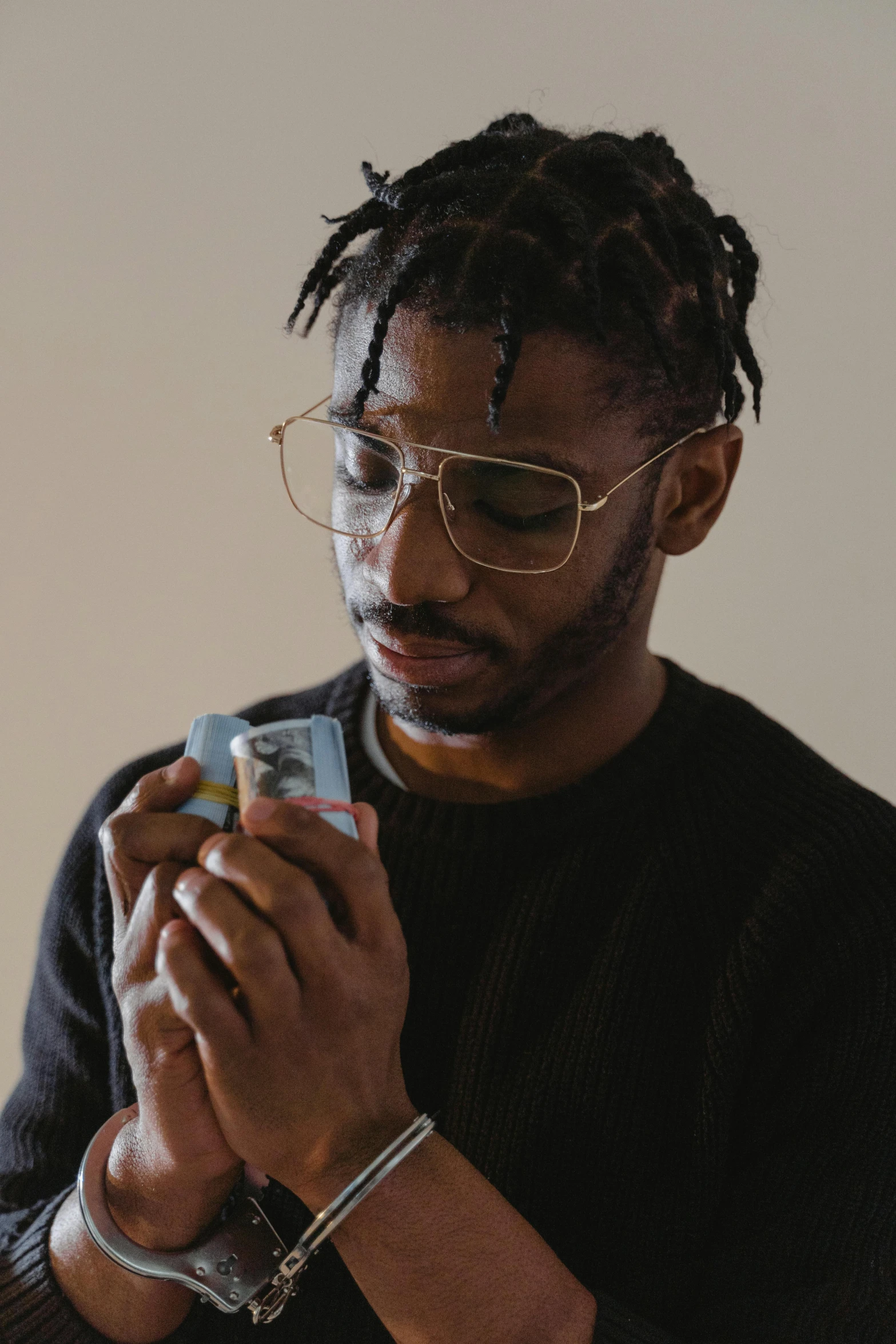 a man wearing glasses looking at his cell phone, an album cover, inspired by Terrell James, trending on pexels, visual art, ashteroth, chewing on a video card, praying with tobacco, handsome man
