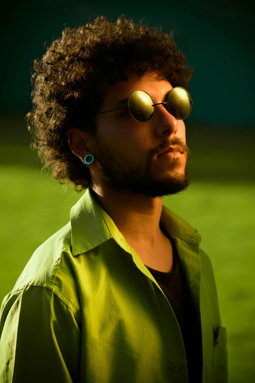 a man wearing sunglasses and a green shirt, by Youssef Howayek, trending on pexels, curly haired, earbuds jewelry, v ray, backlight glow