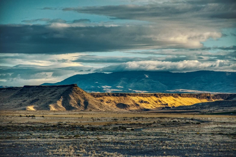 a desert landscape with mountains in the distance, by Jeffrey Smith, pexels contest winner, land art, late afternoon light, black mesa, panoramic, idaho